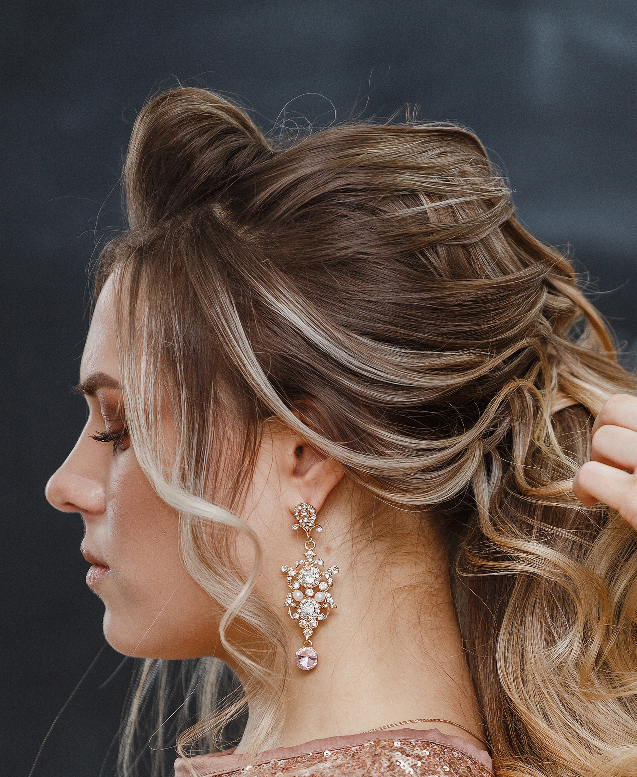 Hairdresser using hairspray on client’s hair at salon